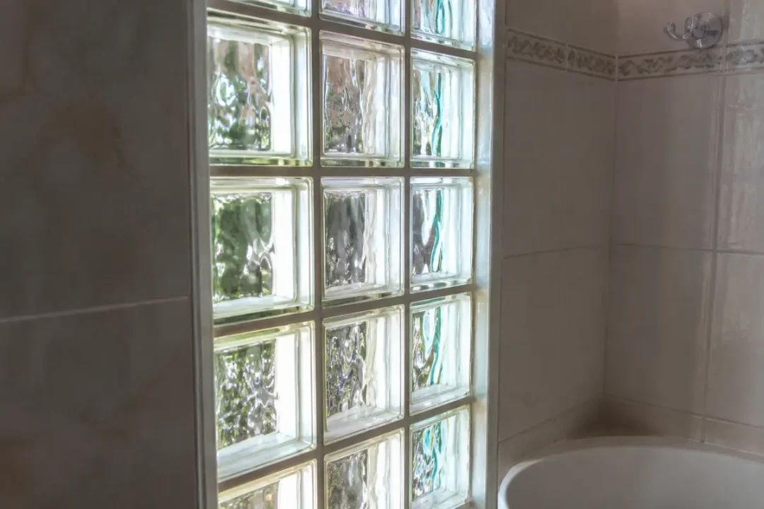 Mur de carreaux de verre laissant passer la lumière dans une salle de bain.
